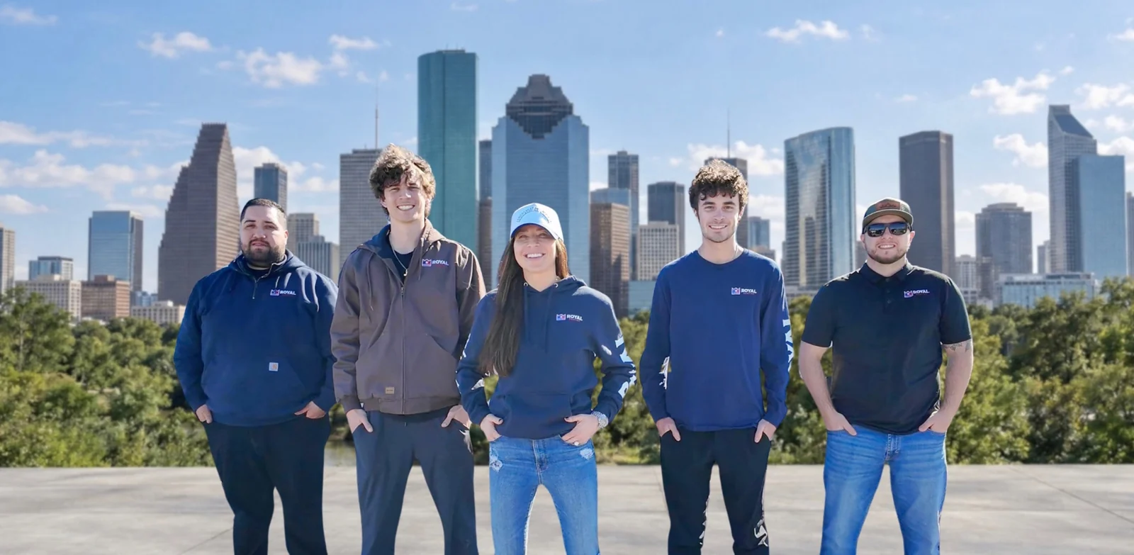 Royal Roofing team with a Houston skyline background.